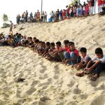 Spectators watch kids releasing terrapins
